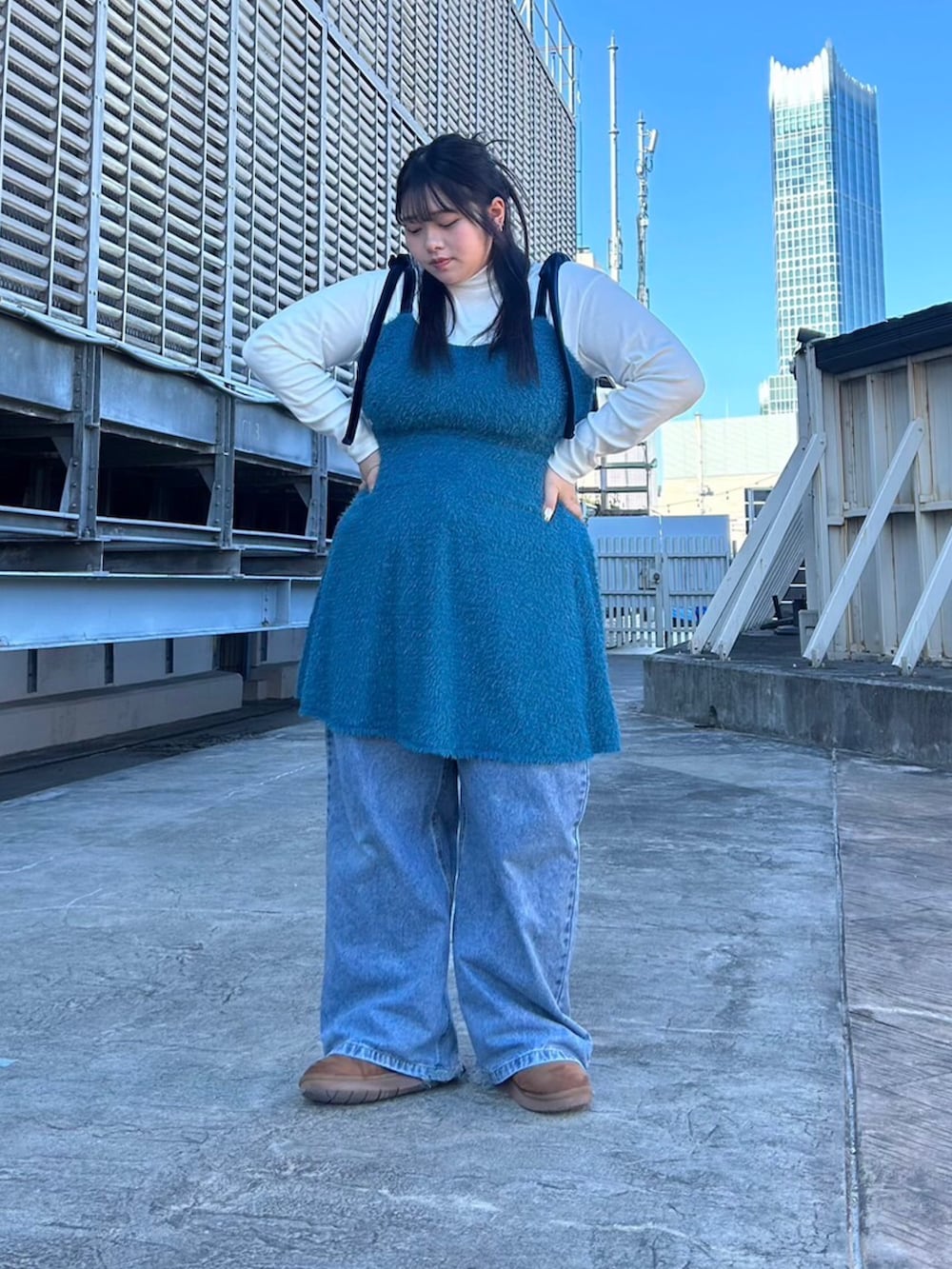 ブルー系のワンピース、ホワイト系のニット/セーター、ブルー系のデニムパンツを着用したレディースの冬コーディネートの2枚目の写真