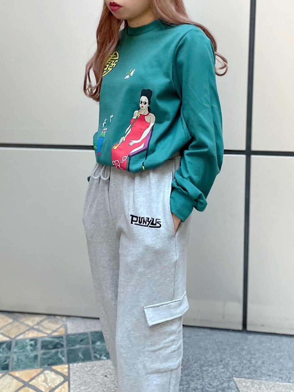 グリーン系のTシャツ/カットソー、グレー系のスウェットパンツ、ブラック系のMA-1を着用したレディースの秋コーディネートの3枚目の写真