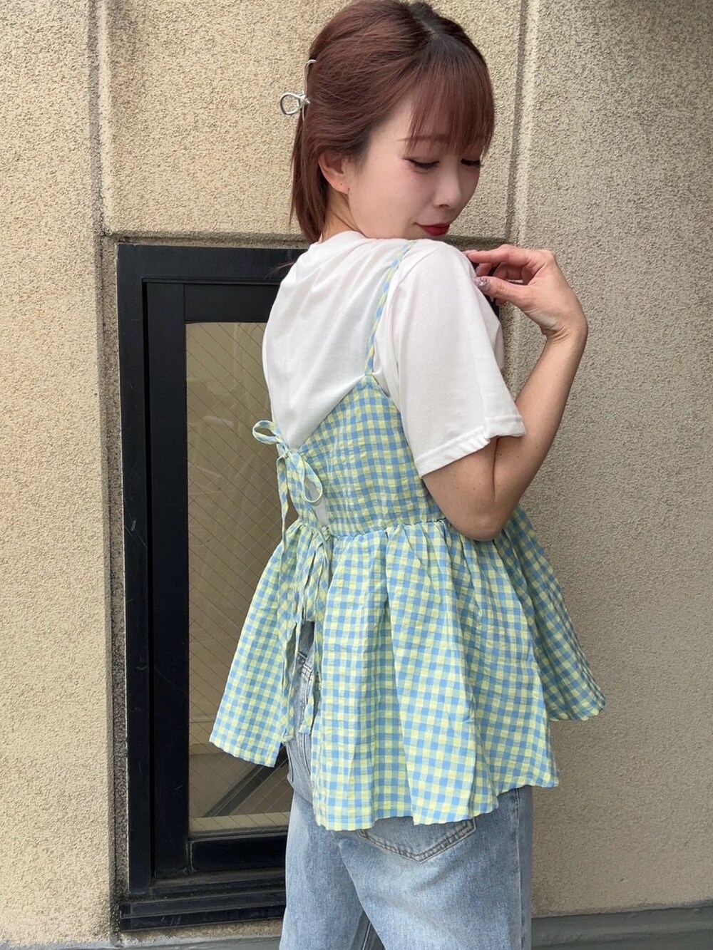 ブルー系のデニムパンツ、イエロー系のキャミソール、ホワイト系のTシャツ/カットソーを着用したレディースの夏コーディネートの3枚目の写真