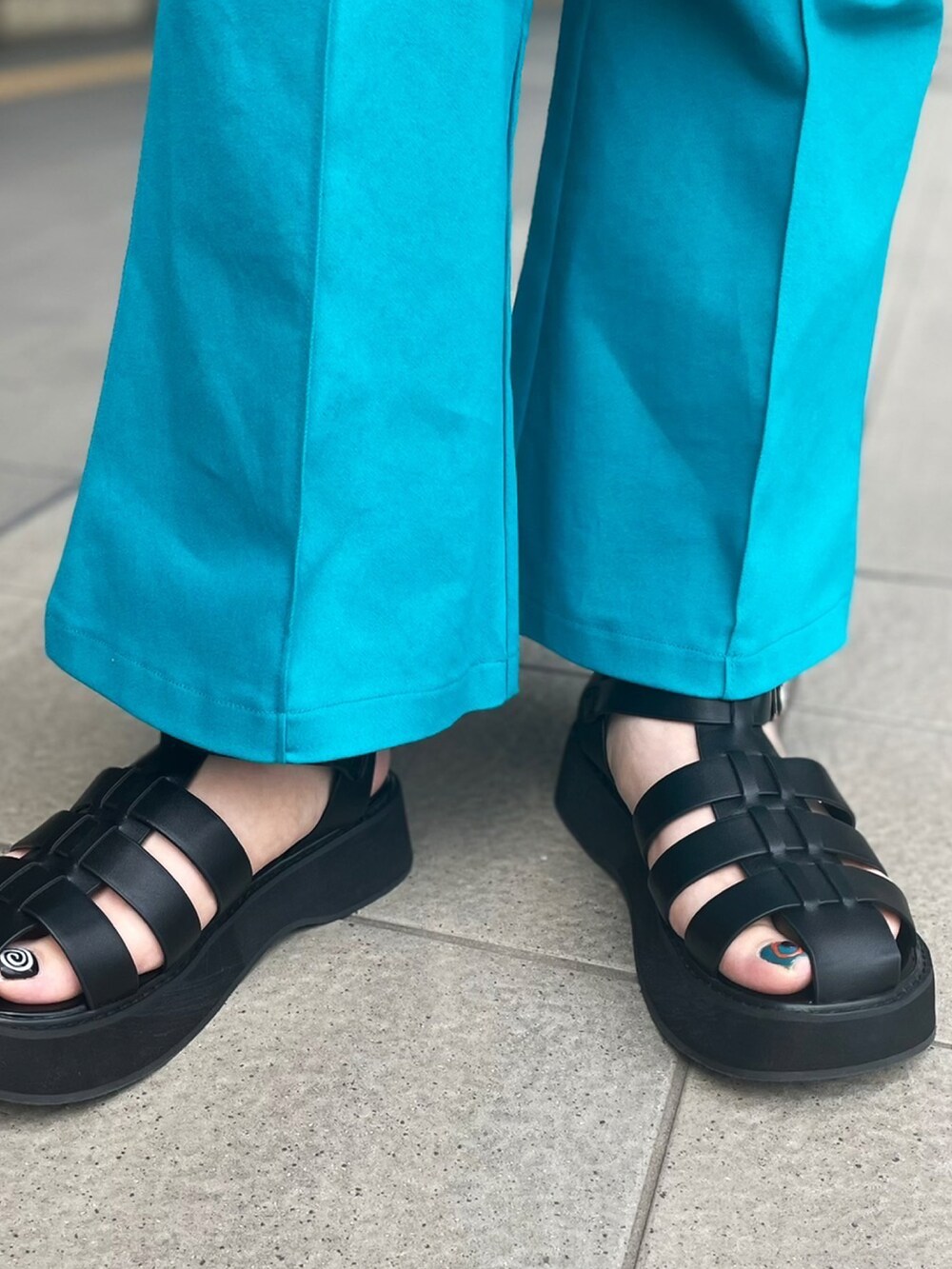 ベージュ系のワンピース、グリーン系のその他パンツ、ブラック系のサンダルを着用したレディースの春コーディネートの2枚目の写真