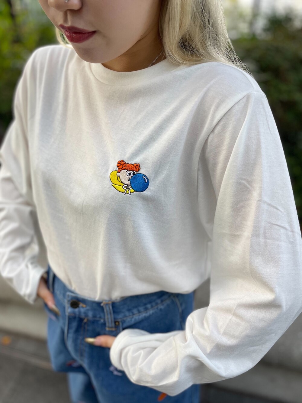 ホワイト系のTシャツ/カットソー、ブルー系のデニムパンツを着用したレディースの秋コーディネートの3枚目の写真