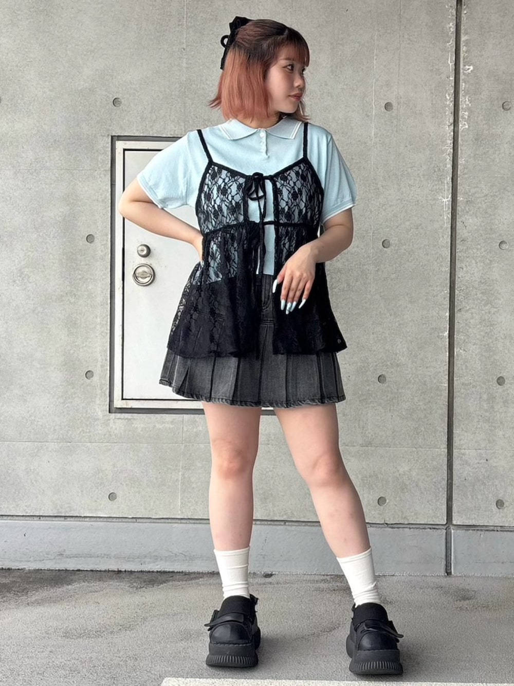 ブルー系のポロシャツ、ブラック系のワンピース、ブラック系のデニムスカートを着用したレディースの夏コーディネートの2枚目の写真