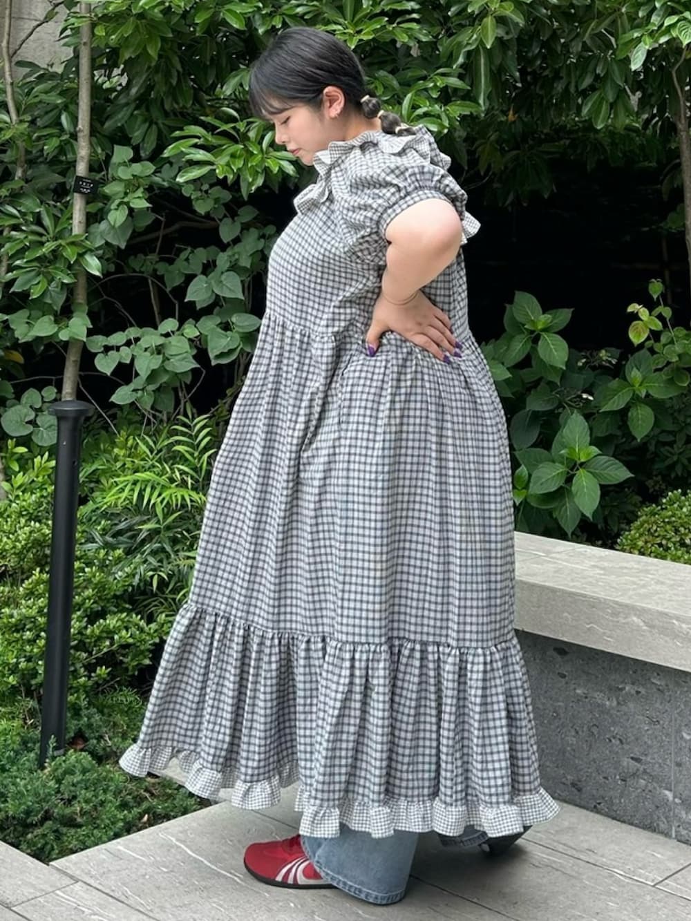 ブラック系のワンピース、ブルー系のデニムパンツを着用したレディースの夏コーディネートの3枚目の写真