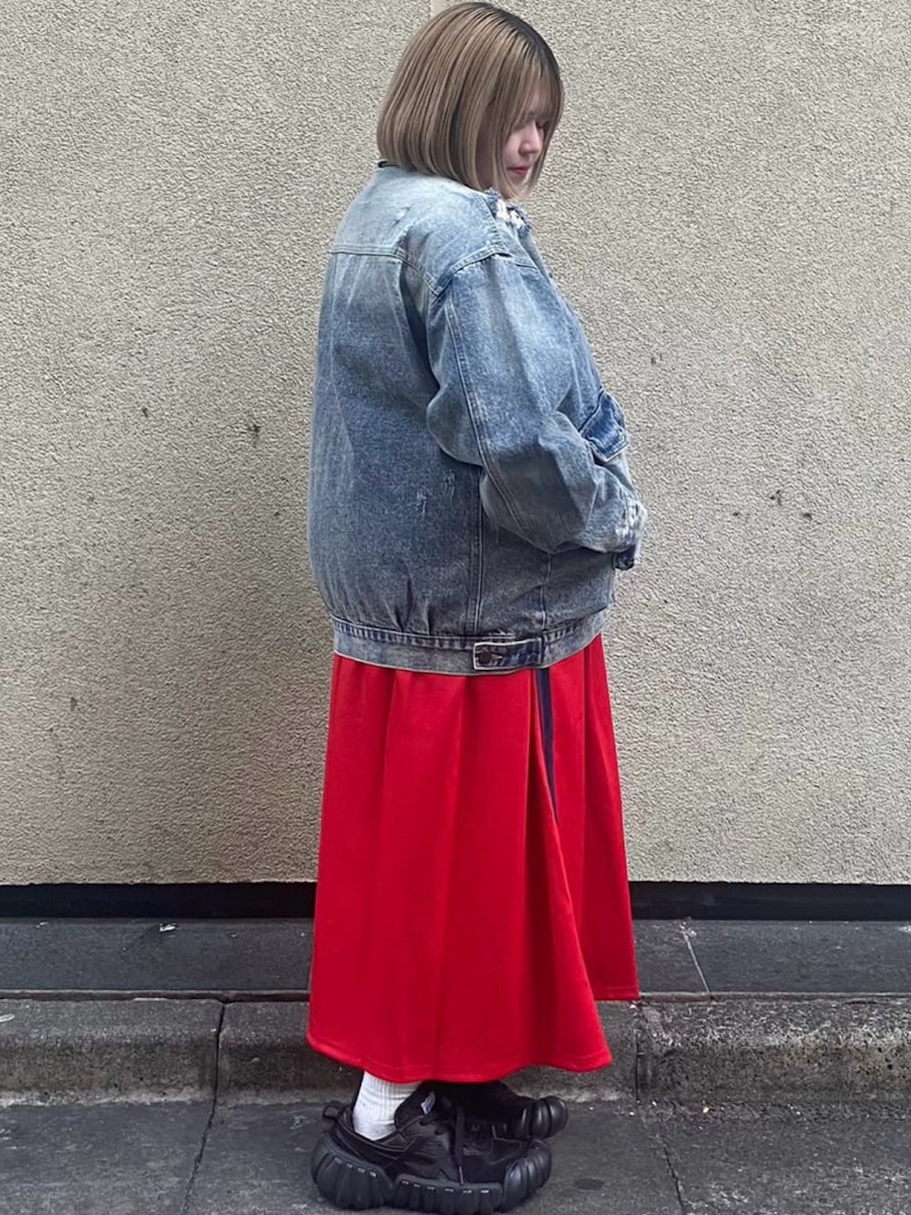 レッド系のスカート、ブルー系のデニムジャケットを着用したレディースの冬コーディネートの3枚目の写真