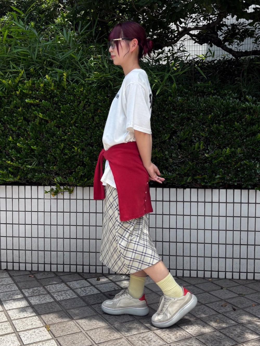ベージュ系のスカート、レッド系のカーディガン/ボレロ、ホワイト系のTシャツ/カットソーを着用したレディースの夏コーディネートの2枚目の写真