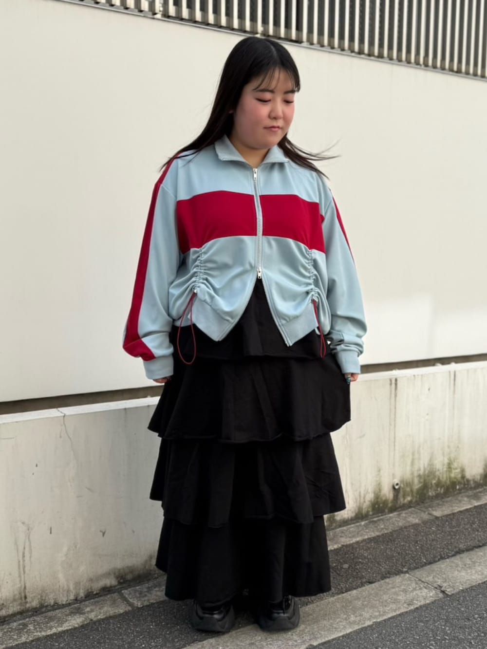 ブラック系のスカート、ブルー系のジャージを着用したレディースの春コーディネートの2枚目の写真