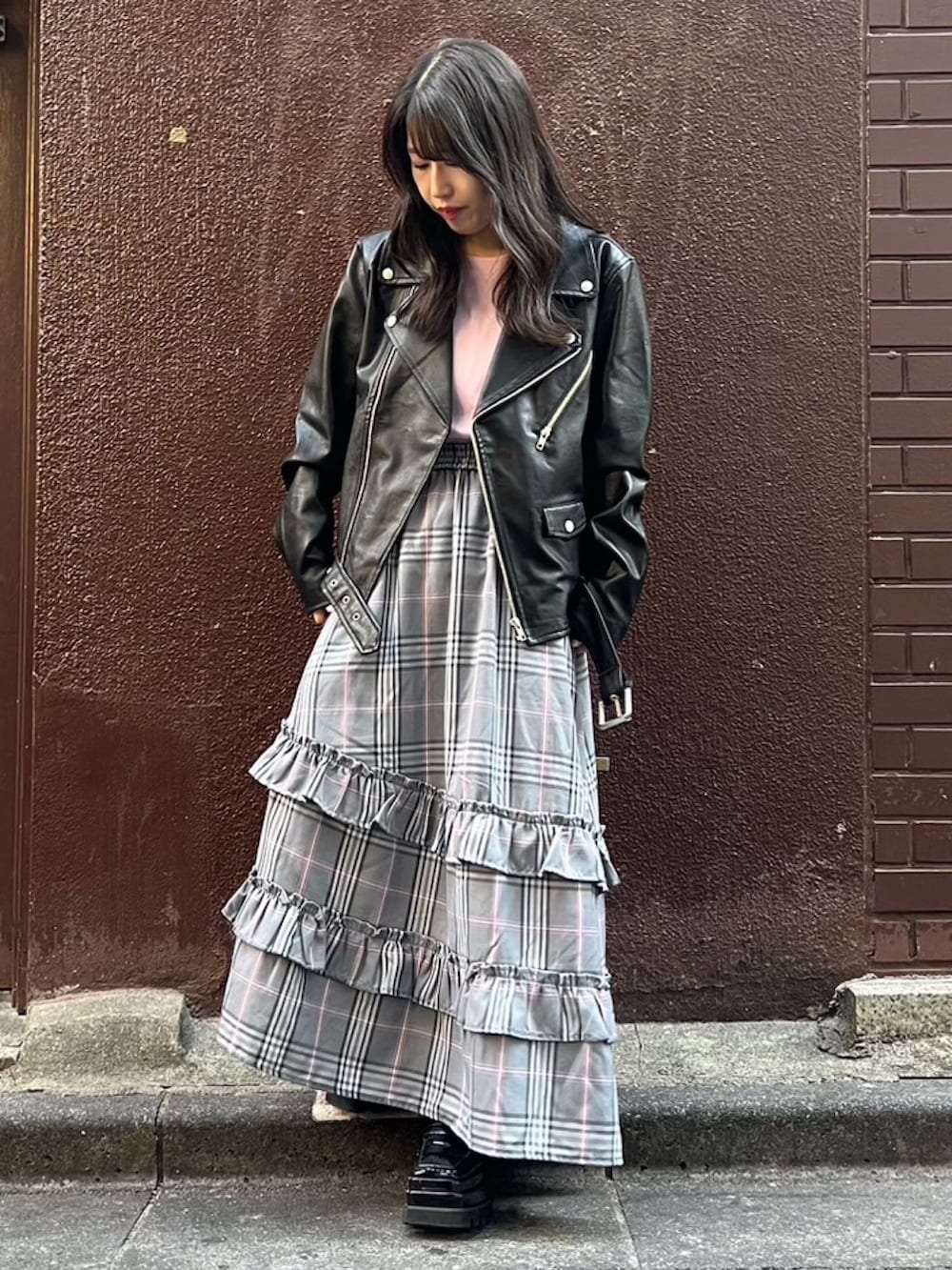 グレー系のスカート、ブラック系のライダースジャケットを着用したレディースの秋コーディネートの2枚目の写真