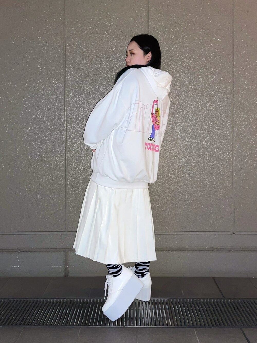ホワイト系のパーカー、ホワイト系のスカート、ホワイト系のスニーカーを着用したレディースの春コーディネートの2枚目の写真