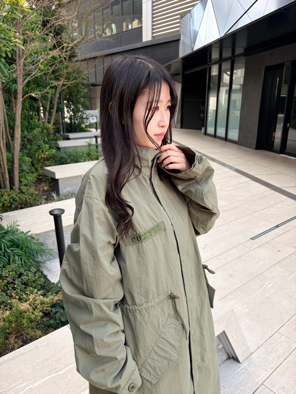 イエロー系のTシャツ/カットソー、グリーン系のモッズコート、グレー系のスカートを着用したレディースの冬コーディネートの5枚目の写真