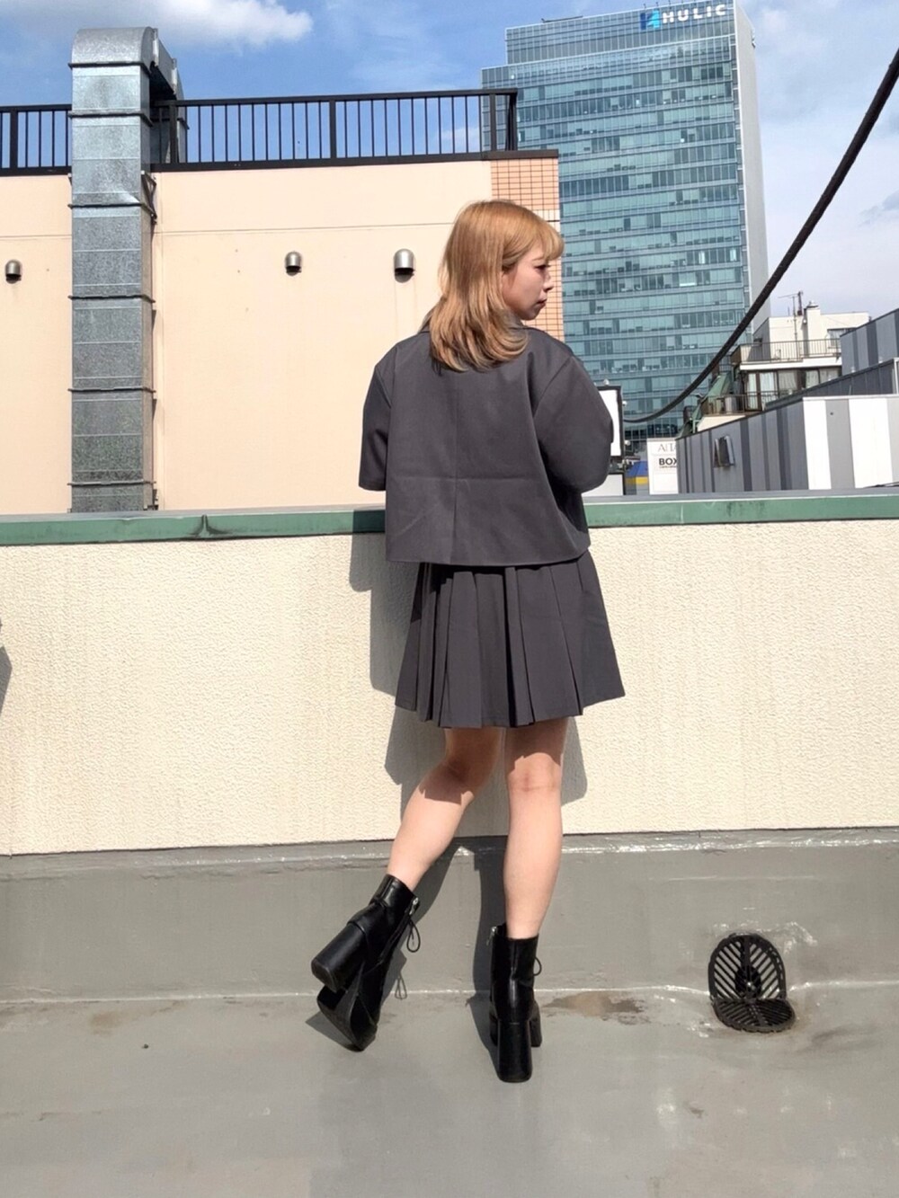 グレー系のテーラードジャケット、グレー系のスカート、ホワイト系のシャツ/ブラウスを着用したレディースの夏コーディネートの2枚目の写真