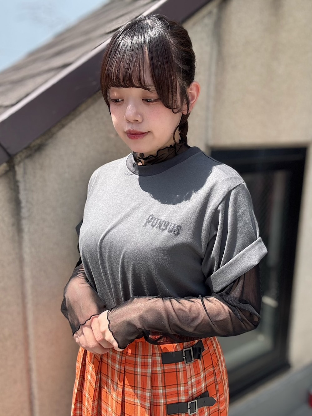 オレンジ系のスカート、ブラック系のTシャツ/カットソー、ブラック系のTシャツ/カットソーを着用したレディースの春コーディネートの5枚目の写真