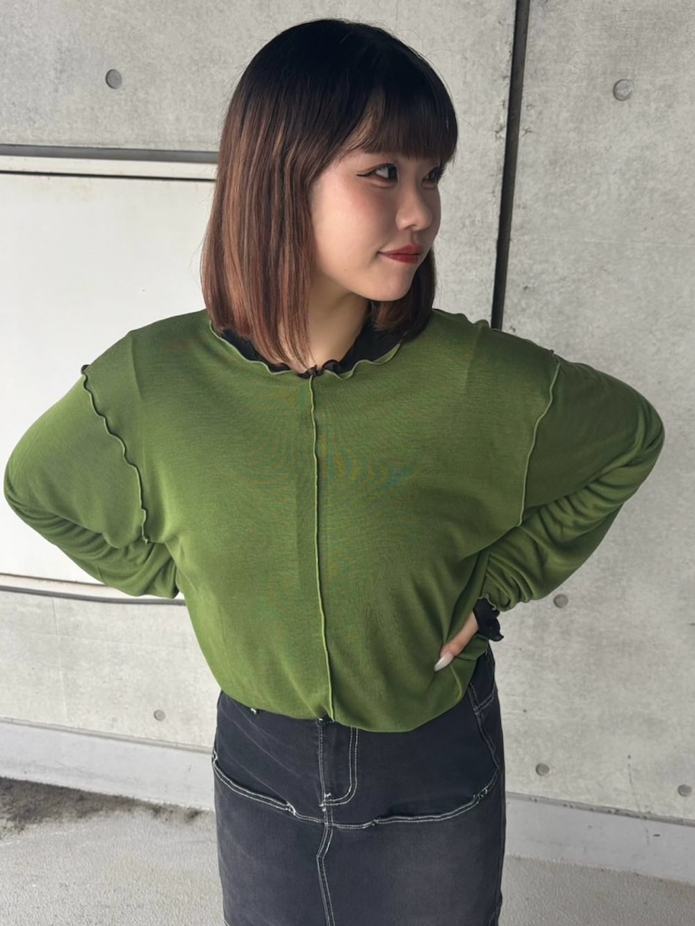 ブラック系のスカート、グリーン系のTシャツ/カットソーを着用したレディースの秋コーディネートの3枚目の写真