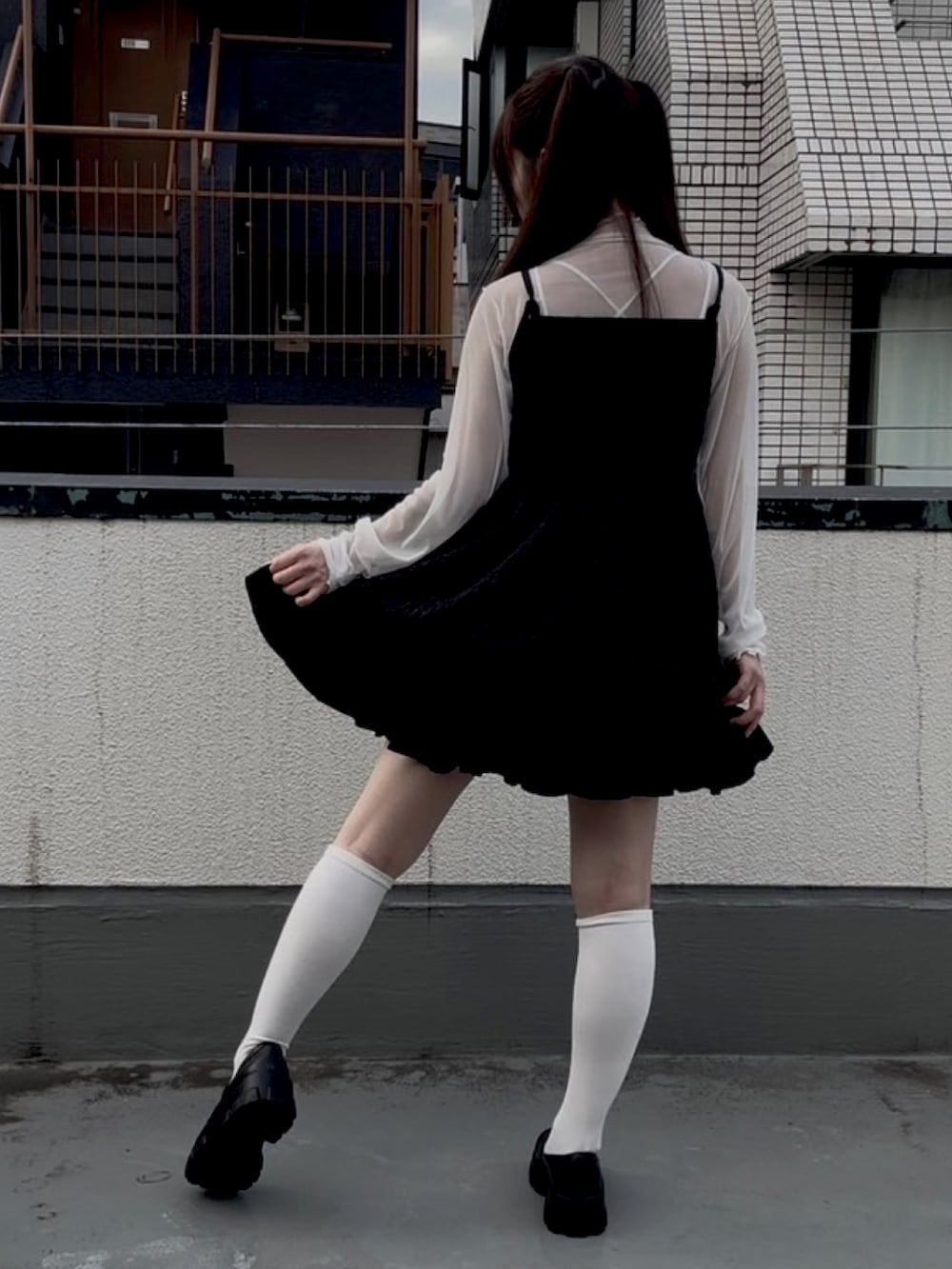 ブラック系のスカート、ブラック系のキャミソール、ホワイト系のTシャツ/カットソーを着用したレディースの秋コーディネートの2枚目の写真