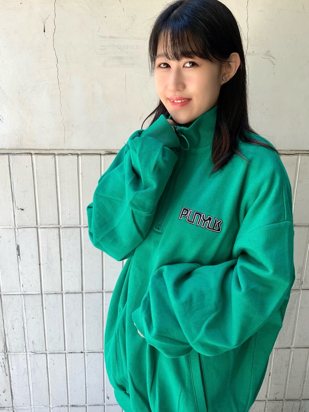 グリーン系のスウェット、ホワイト系のスニーカー、ホワイト系のTシャツ/カットソーを着用したレディースの秋コーディネートの3枚目の写真