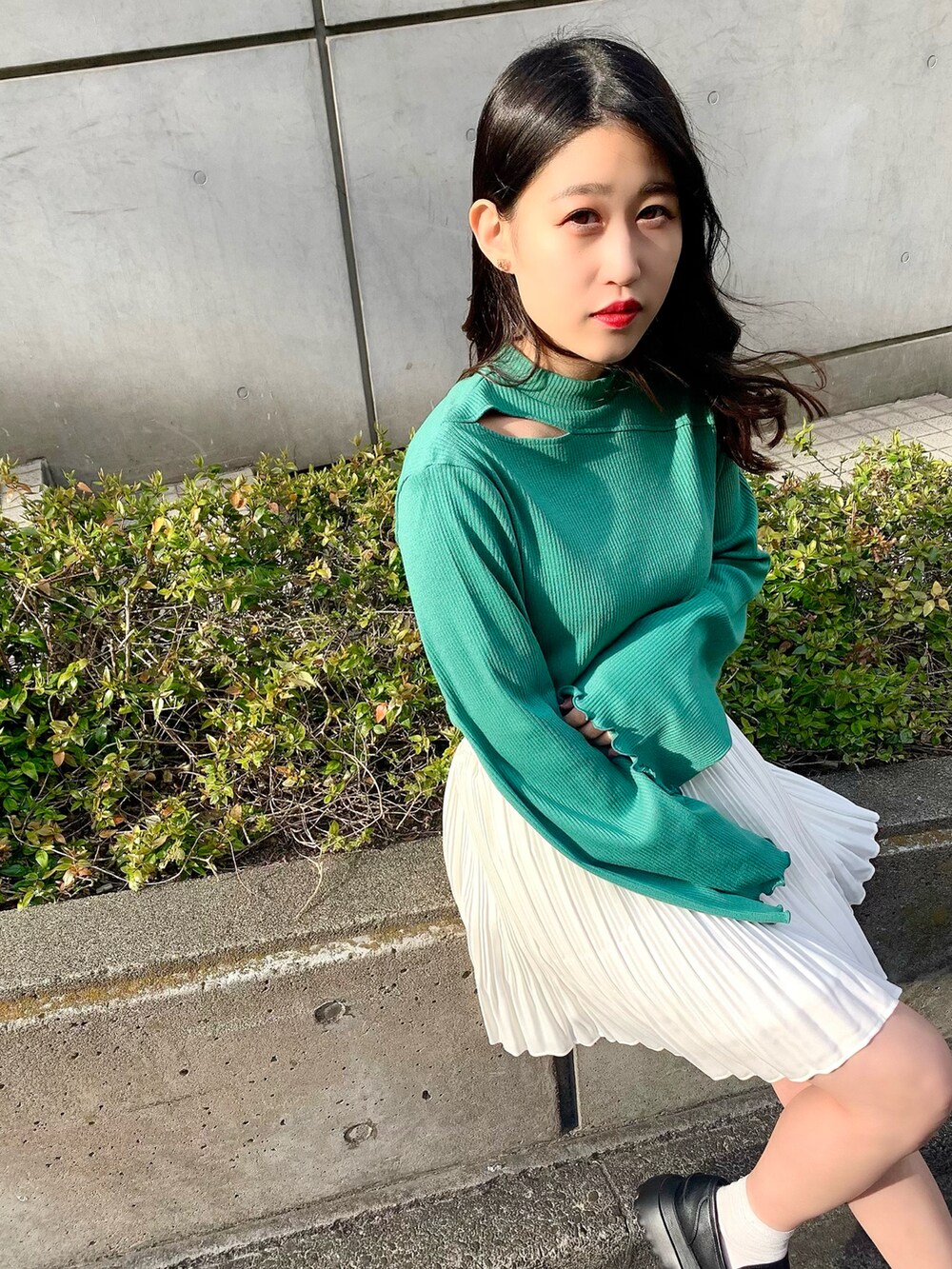 ブラック系のローファー、グリーン系のTシャツ/カットソー、ホワイト系のスカートを着用したレディースの春コーディネートの3枚目の写真