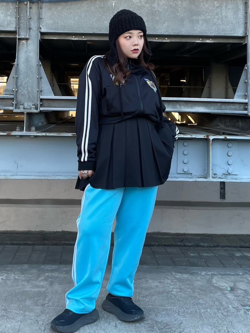 ブラック系のジャージ、ブラック系のスカート、ブルー系のその他パンツを着用したレディースの冬コーディネートの2枚目の写真