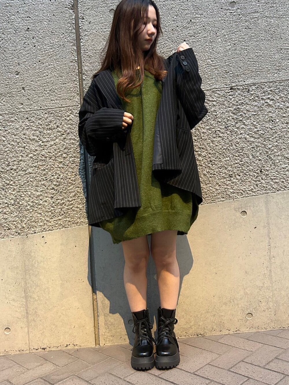 グリーン系のニット/セーター、グレー系のテーラードジャケットを着用したレディースの秋コーディネートの2枚目の写真