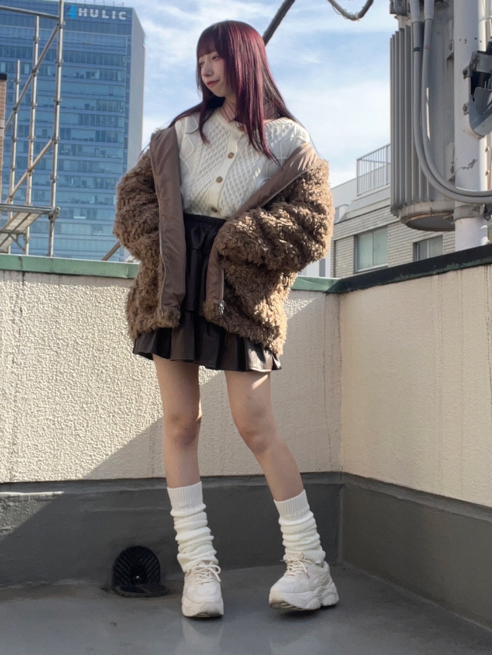 ブラウン系のブルゾン、ブラウン系のスカートを着用したレディースの冬コーディネートの3枚目の写真