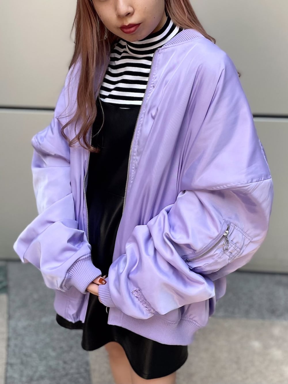 ホワイト系のTシャツ/カットソー、ブラック系のジャンパースカート、パープル系のMA-1を着用したレディースの冬コーディネートの2枚目の写真