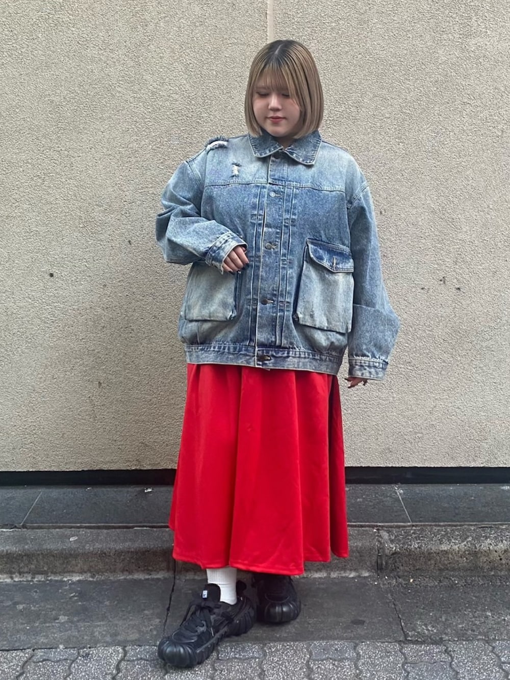 レッド系のスカート、ブルー系のデニムジャケットを着用したレディースの冬コーディネートの2枚目の写真