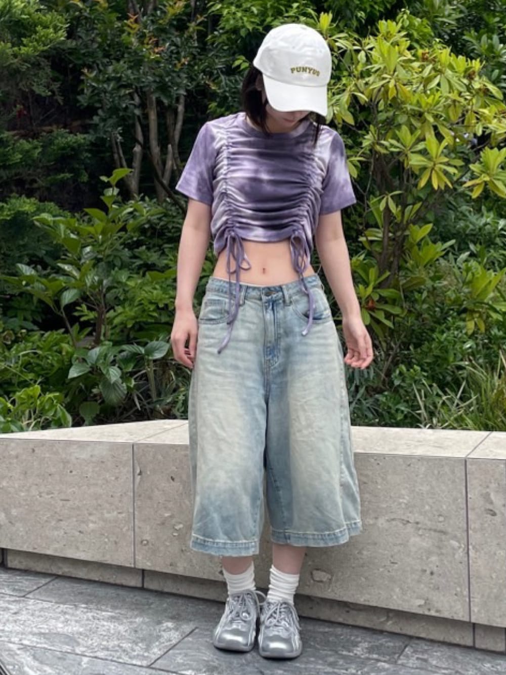 ブルー系のデニムパンツ、パープル系のTシャツ/カットソー、ホワイト系のキャップを着用したレディースの春コーディネートの2枚目の写真