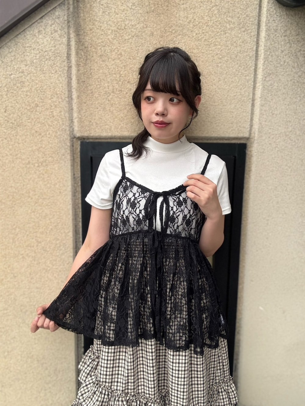 ベージュ系のスカート、ブラック系のチュニック、ホワイト系のTシャツ/カットソーを着用したレディースの夏コーディネートの6枚目の写真