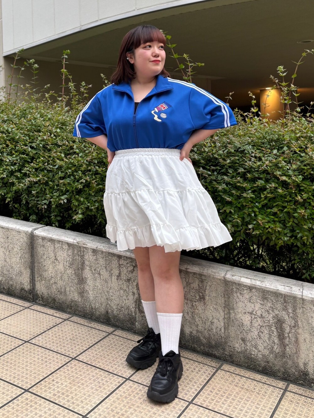 ホワイト系のスカート、ブルー系のジャージを着用したレディースの春コーディネートの2枚目の写真