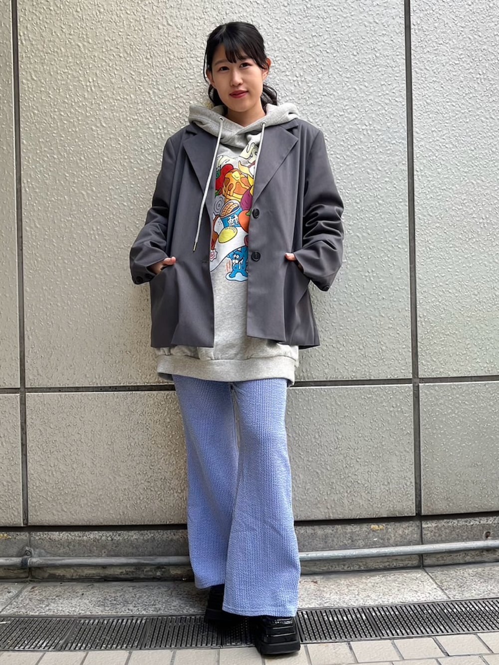 グレー系のパーカー、グレー系のテーラードジャケット、ブルー系のその他パンツを着用したレディースの春コーディネートの2枚目の写真