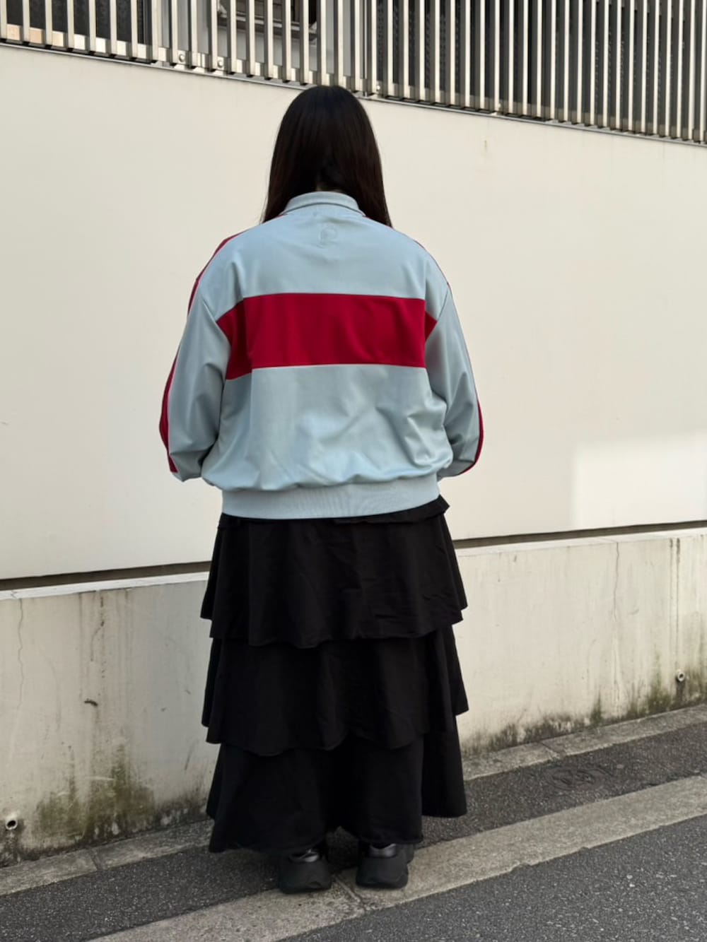 ブラック系のスカート、ブルー系のジャージを着用したレディースの春コーディネートの3枚目の写真