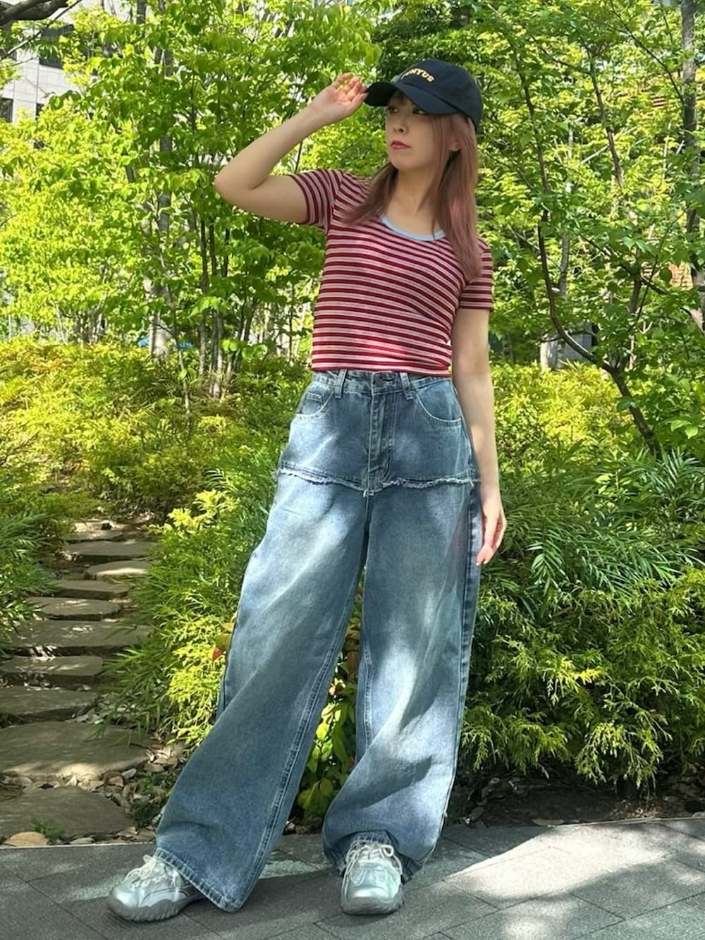 ブルー系のデニムパンツ、レッド系のTシャツ/カットソー、ブルー系のキャップを着用したレディースの春コーディネートの6枚目の写真
