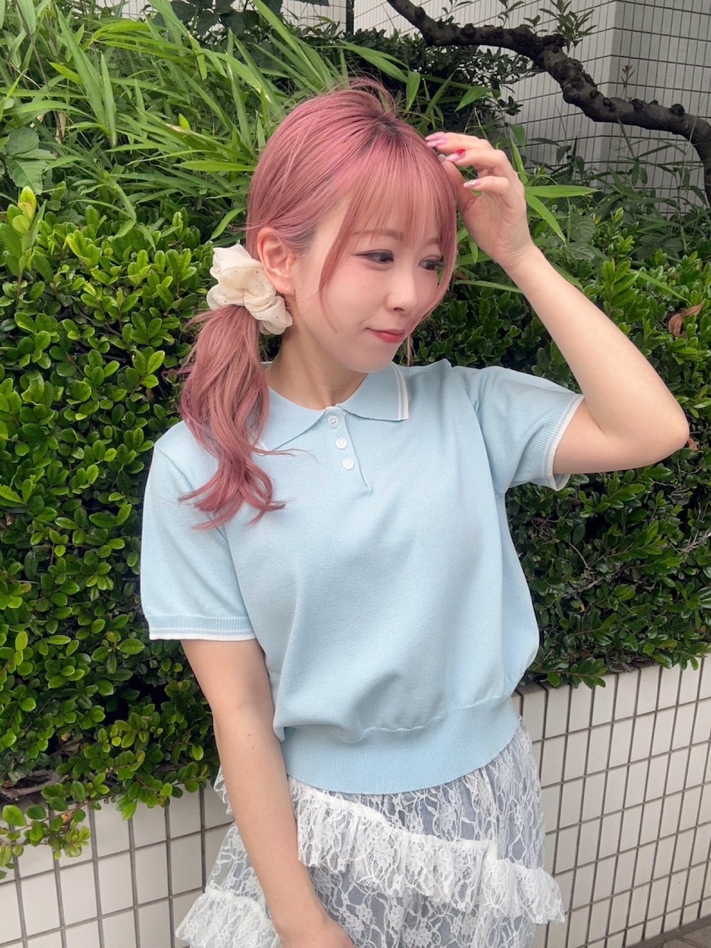 ホワイト系のスカート、ブルー系のポロシャツ、ブルー系のデニムパンツを着用したレディースの夏コーディネートの6枚目の写真