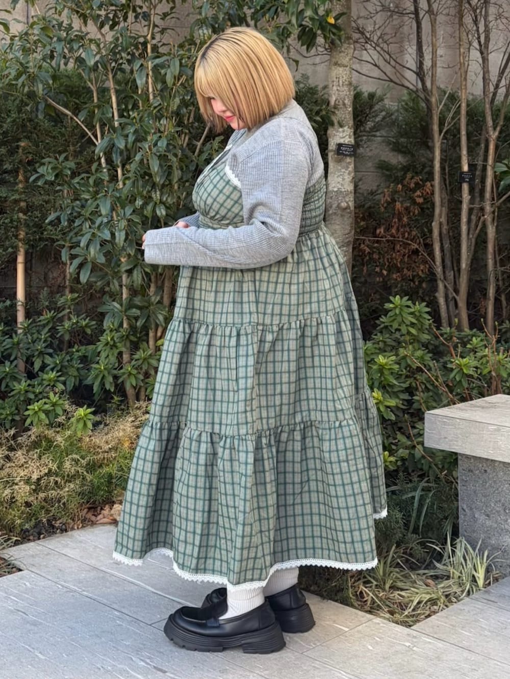 グリーン系のワンピース、グレー系のニット/セーターを着用したレディースの春コーディネートの3枚目の写真