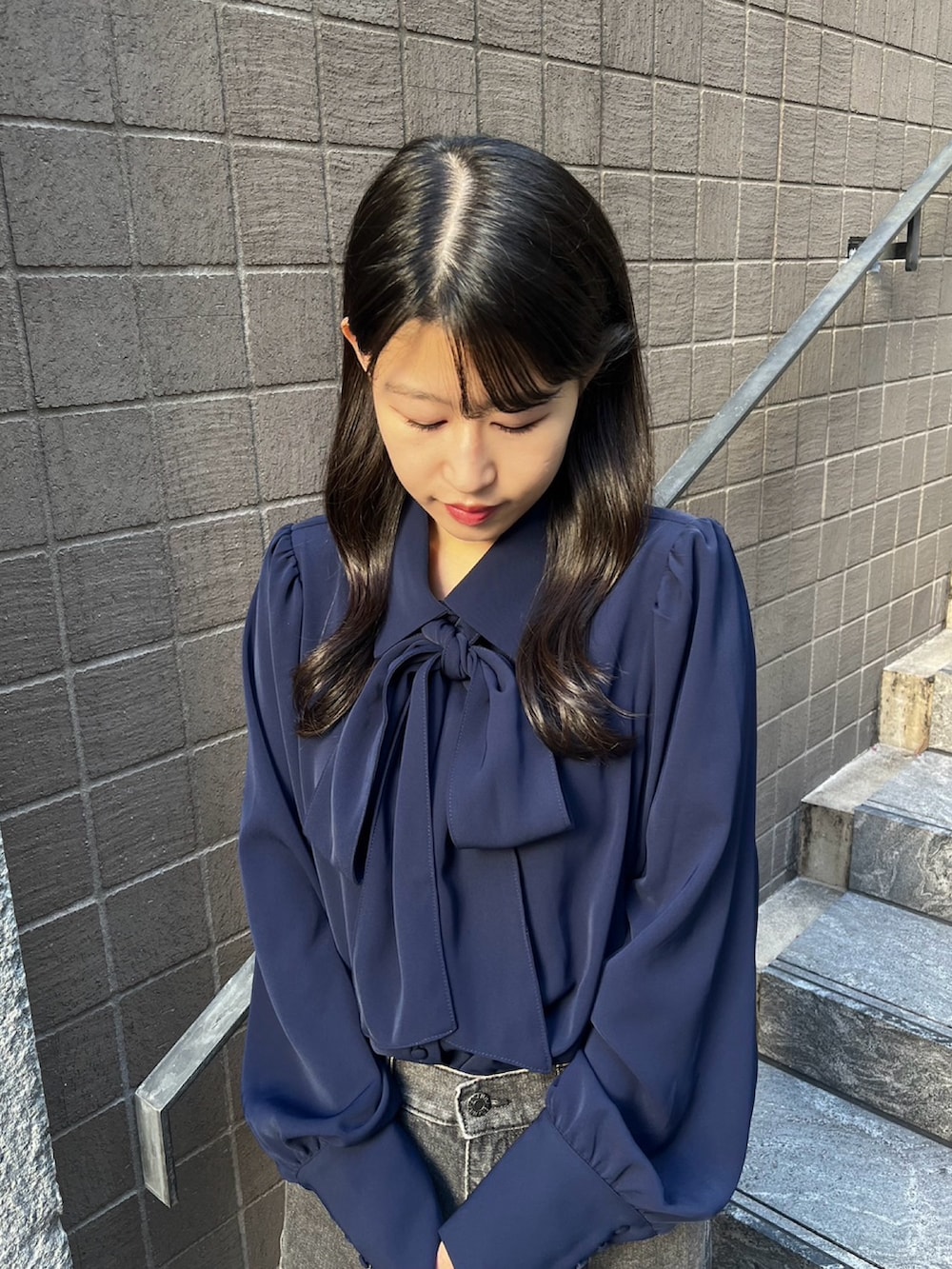 ブラック系のデニムパンツ、ブルー系のシャツ/ブラウスを着用したレディースの秋コーディネートの3枚目の写真