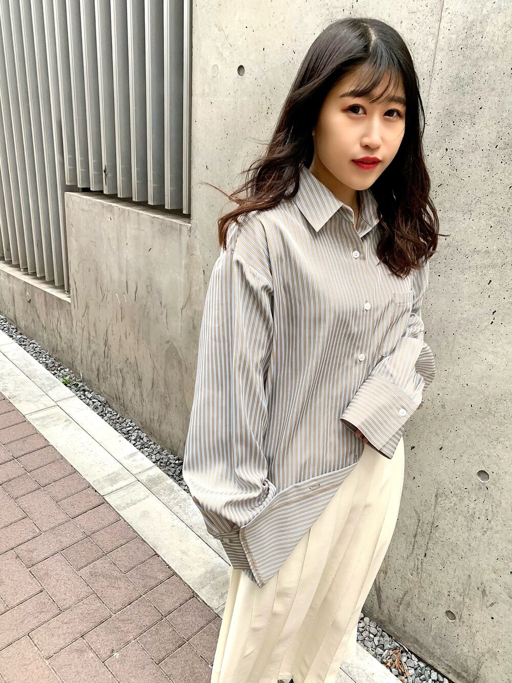 ブラック系のドレスシューズ、ホワイト系のスカート、ブルー系のシャツ/ブラウスを着用したレディースの冬コーディネートの2枚目の写真