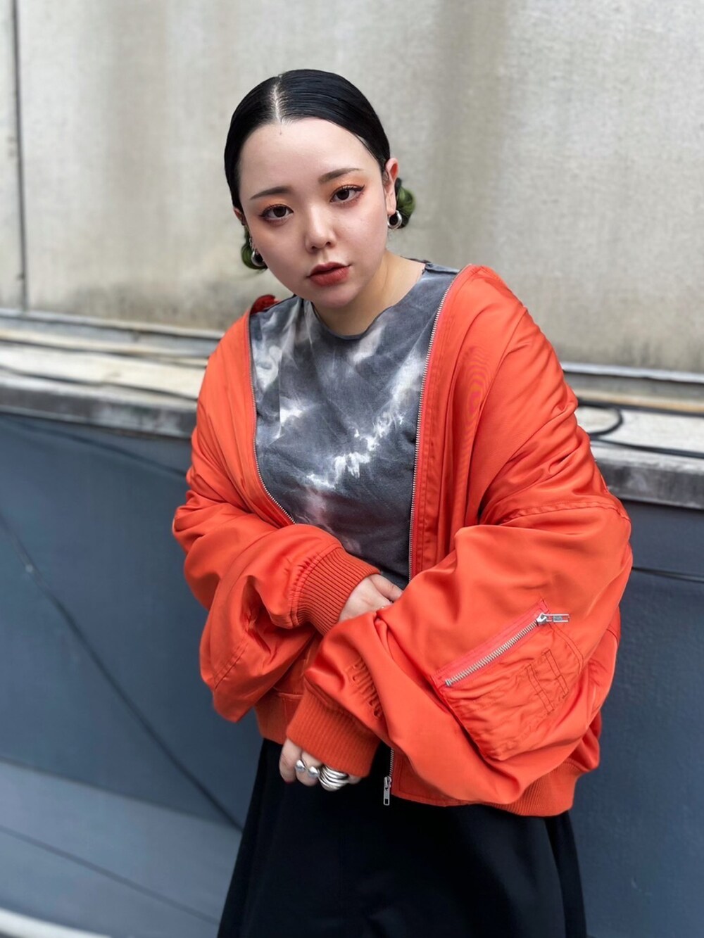 オレンジ系のMA-1、ブラック系のTシャツ/カットソー、ブラック系のスカートを着用したレディースの秋コーディネートの2枚目の写真