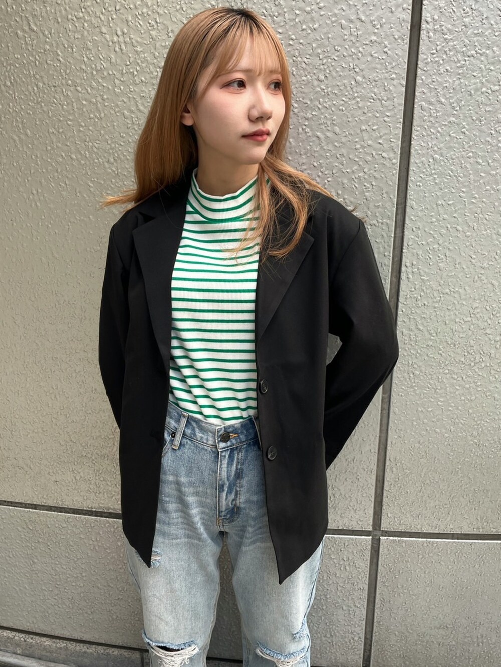 ブルー系のデニムパンツ、グリーン系のTシャツ/カットソー、ブラック系のテーラードジャケットを着用したレディースの春コーディネートの2枚目の写真