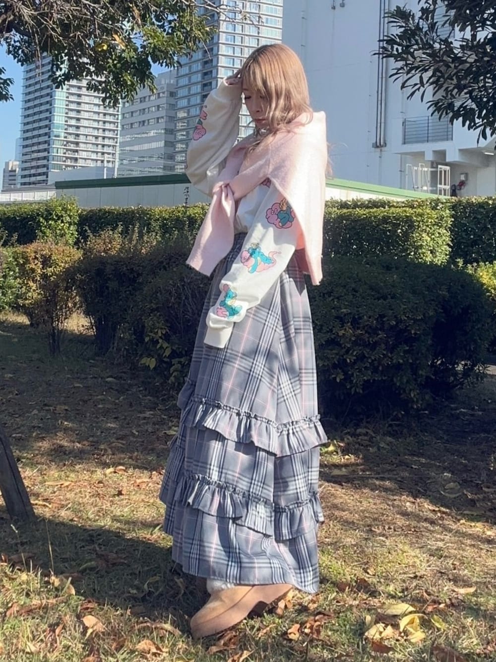 グレー系のスカート、ホワイト系のTシャツ/カットソー、ピンク系のニット/セーターを着用したレディースの秋コーディネートの2枚目の写真