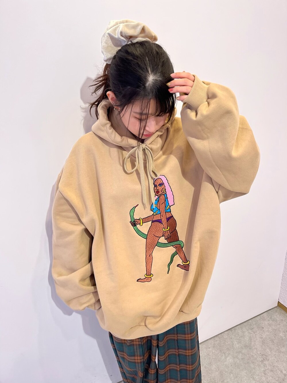 ベージュ系のパーカー、グリーン系のその他パンツを着用したレディースの冬コーディネートの2枚目の写真