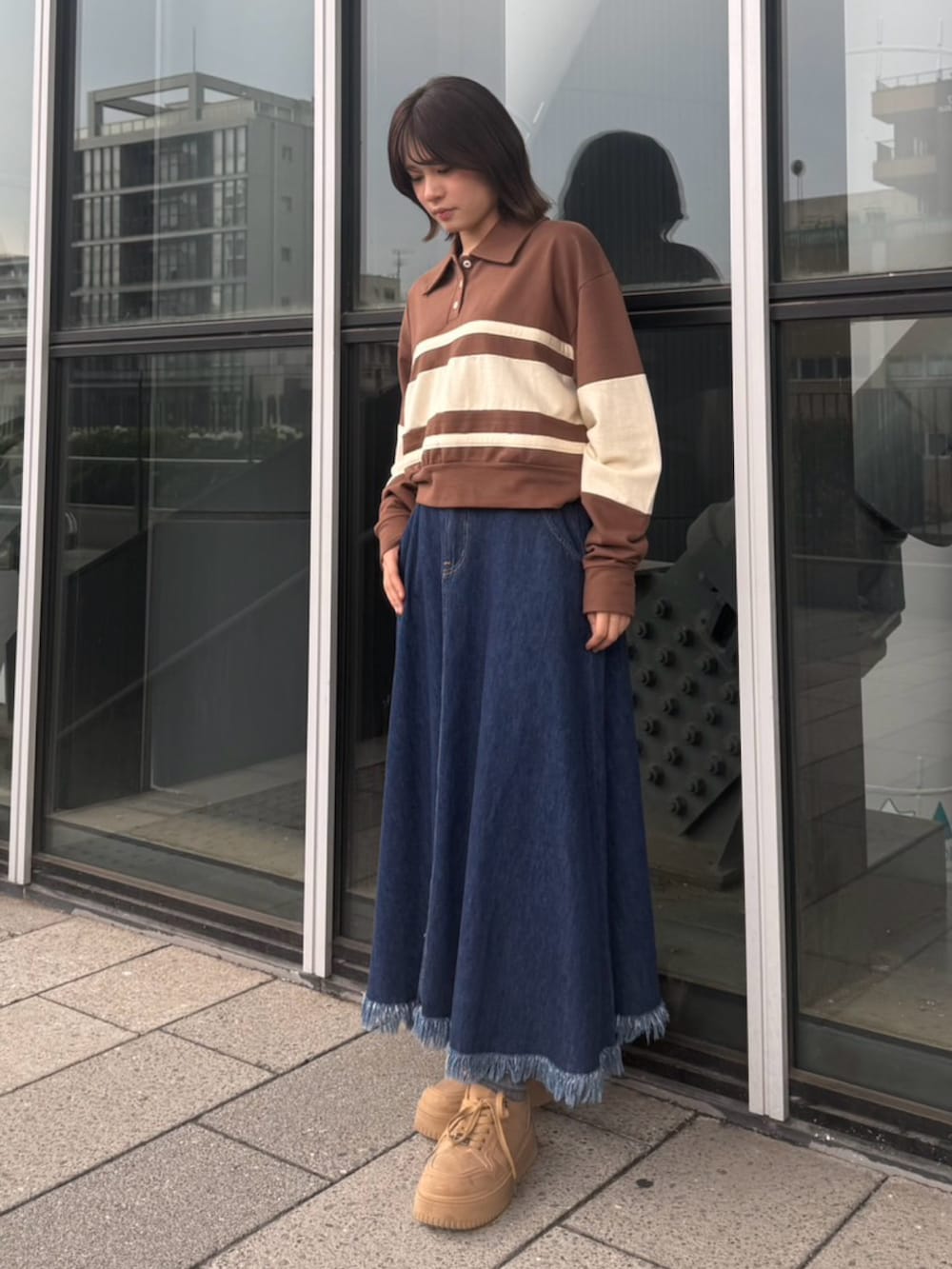 ブルー系のスカート、ブラウン系のスウェットを着用したレディースの春コーディネートの4枚目の写真