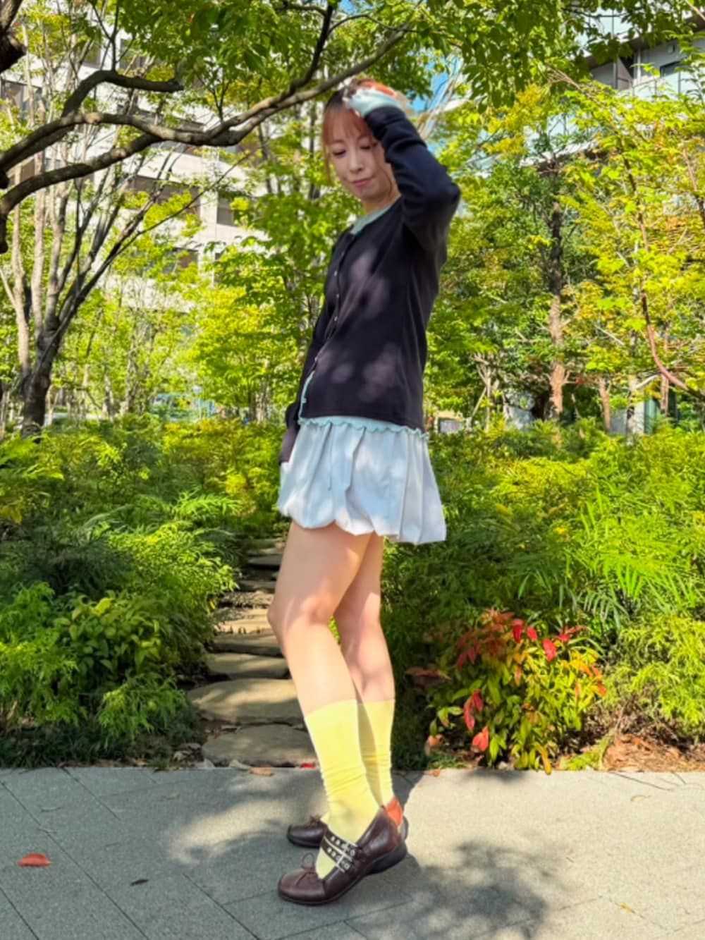 グレー系のスカート、ブルー系のTシャツ/カットソー、ブルー系のカーディガン/ボレロを着用したレディースの秋コーディネートの4枚目の写真