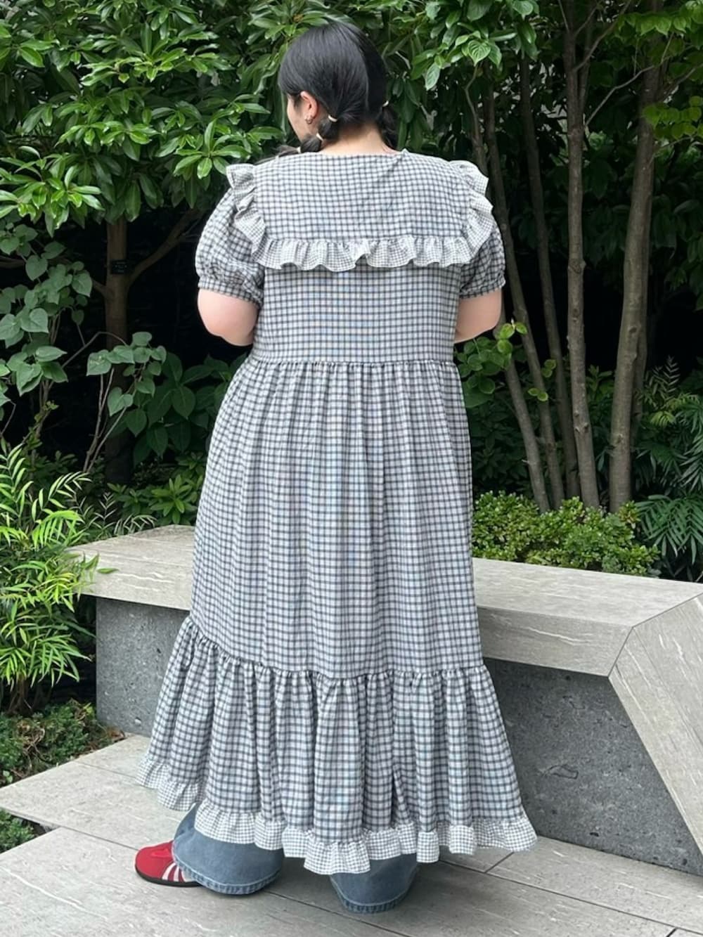 ブラック系のワンピース、ブルー系のデニムパンツを着用したレディースの夏コーディネートの4枚目の写真