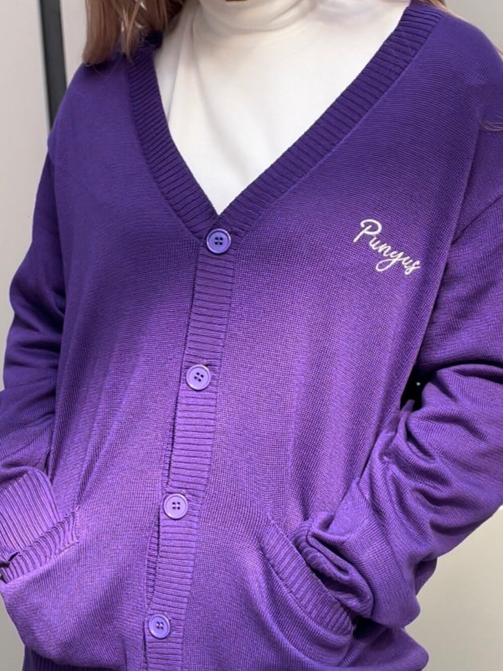 ブラック系のローファー、パープル系のカーディガン/ボレロ、ブラック系のスカートを着用したレディースの秋コーディネートの3枚目の写真