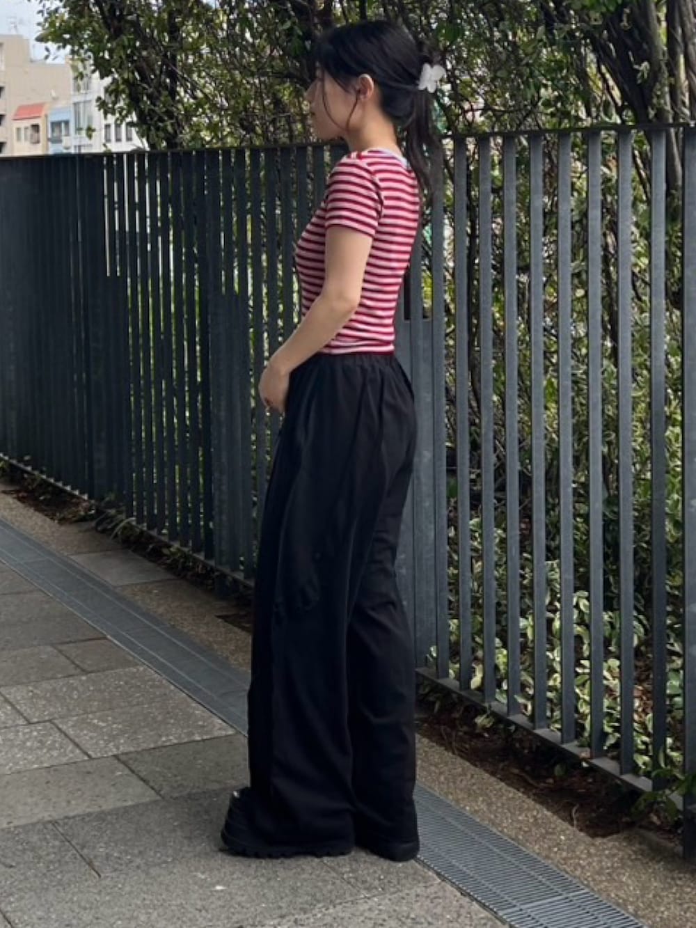 ブラック系のスウェットパンツ、レッド系のTシャツ/カットソーを着用したレディースの夏コーディネートの3枚目の写真