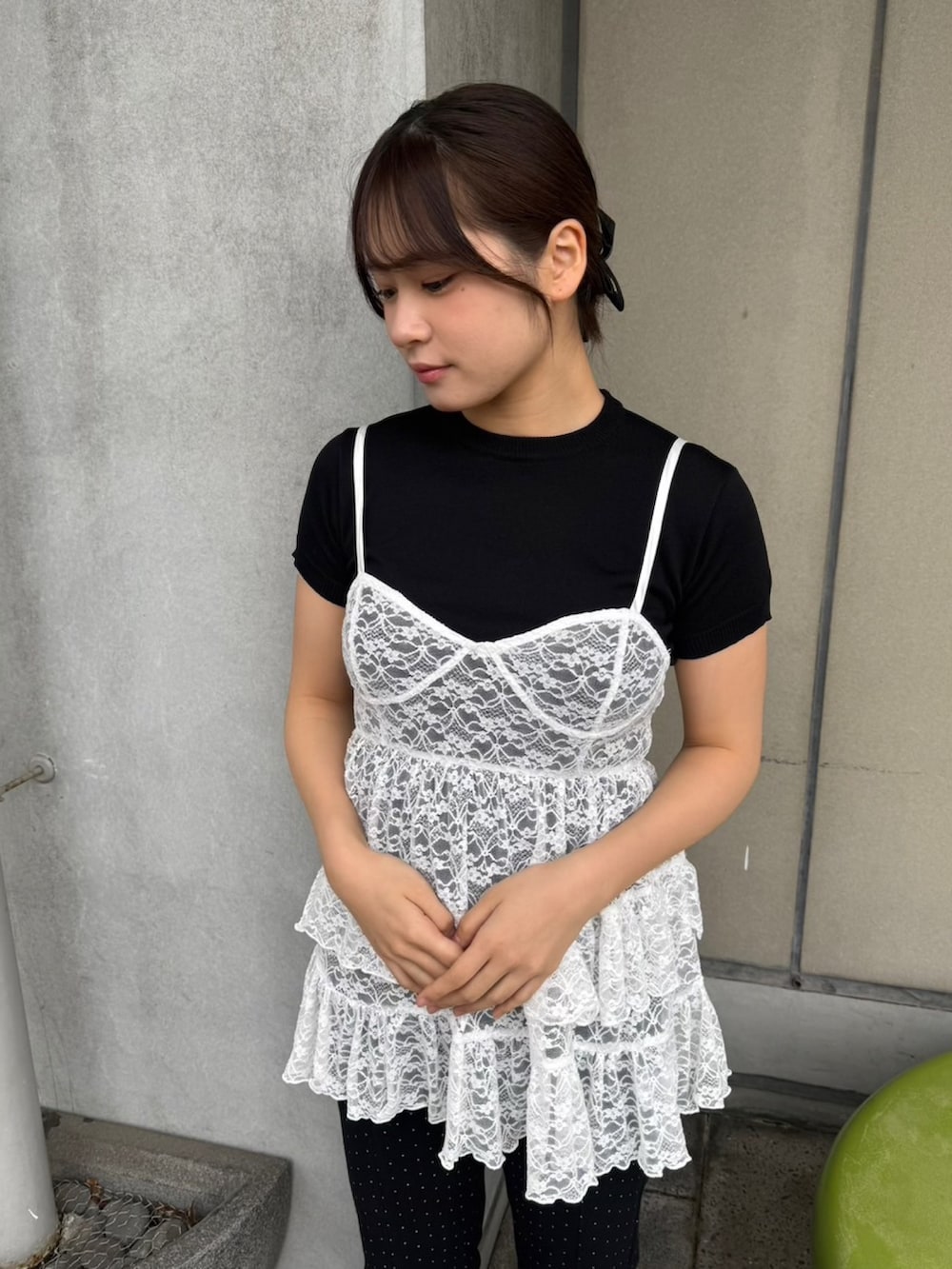 ホワイト系のワンピース、ブラック系のニット/セーター、ブラック系のデニムパンツを着用したレディースの春コーディネートの4枚目の写真