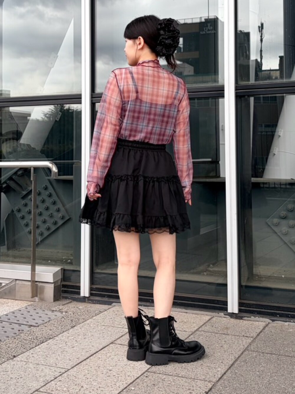 ブラック系のスカート、レッド系のTシャツ/カットソー、ブラック系のキャミソールを着用したレディースの秋コーディネートの4枚目の写真