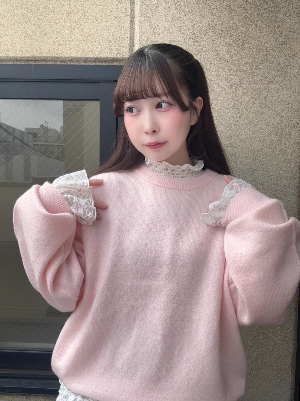 グレー系のスカート、ピンク系のニット/セーター、ホワイト系のTシャツ/カットソーを着用したレディースの冬コーディネートの3枚目の写真