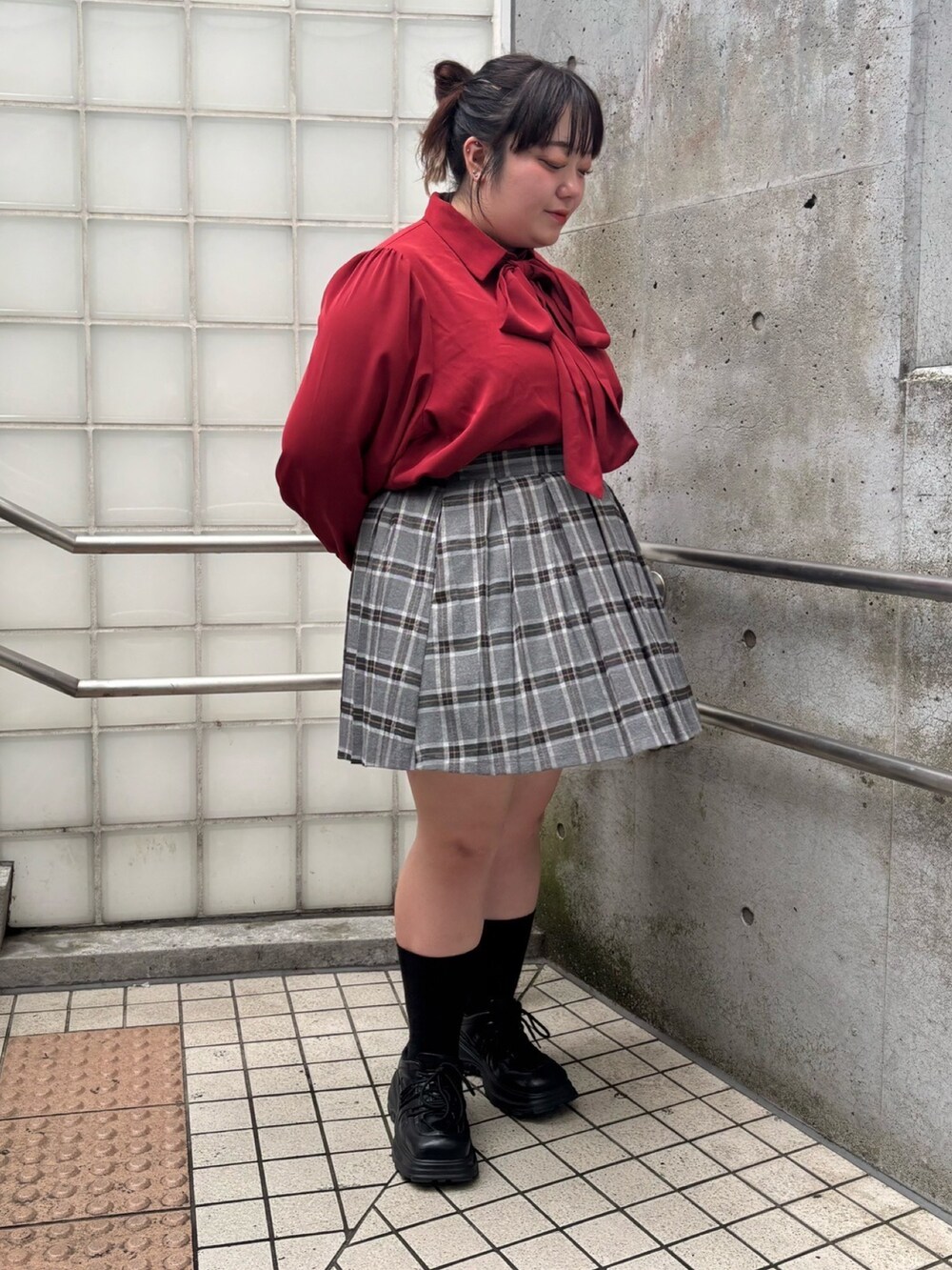 グレー系のスカート、レッド系のシャツ/ブラウスを着用したレディースの秋コーディネートの2枚目の写真