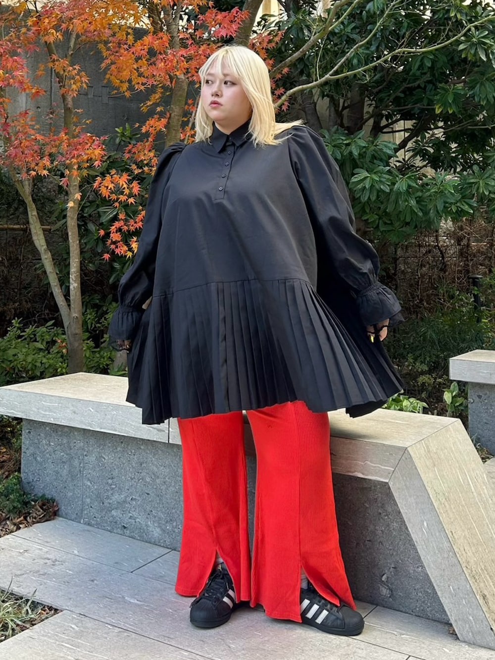 ブラック系のシャツワンピース、レッド系のその他パンツを着用したレディースの冬コーディネートの2枚目の写真