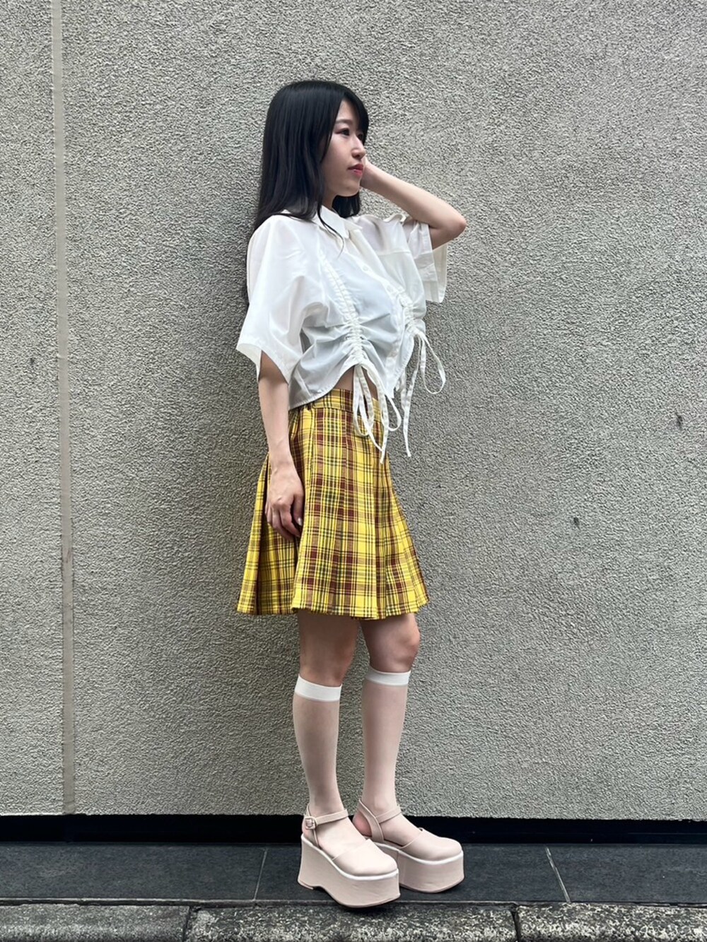 イエロー系のスカート、ホワイト系のシャツ/ブラウスを着用したレディースの夏コーディネートの2枚目の写真