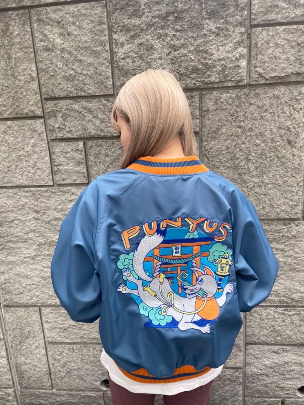 ブルー系のブルゾン、ホワイト系のTシャツ/カットソー、ブラウン系のその他パンツを着用したレディースの冬コーディネートの2枚目の写真